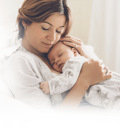 A mother embraces a newborn sleeping on her chest.