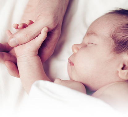 Newborn baby holding hand