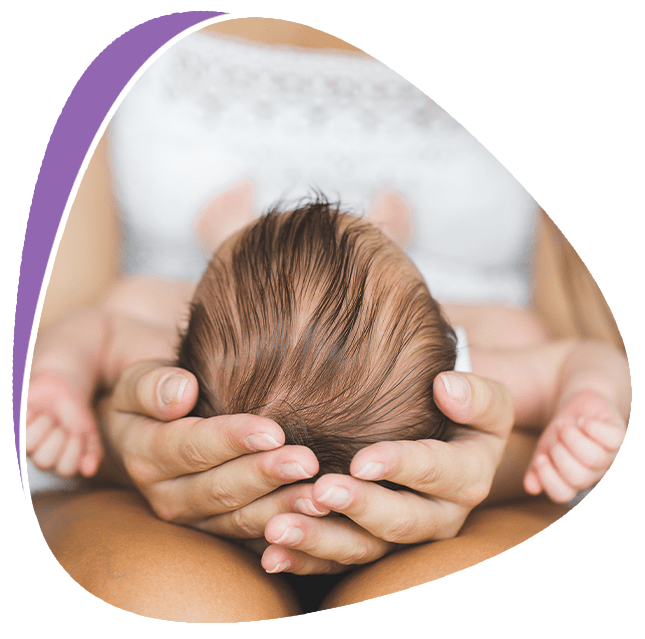 A person gently holds a baby's head with both hands.
