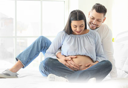 A couple embraces the woman's pregnant belly.